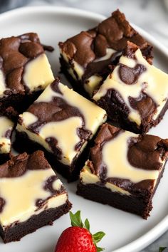 chocolate brownies with white frosting and a strawberry on the side