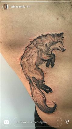 a tattoo on the side of a man's stomach with a fox design in black and grey