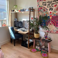 a room with a desk, chair and plant in it