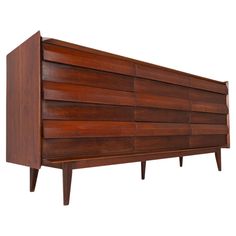 a large wooden dresser sitting on top of a white wall