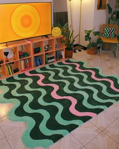 a living room with a large rug on the floor and bookshelves in front of it