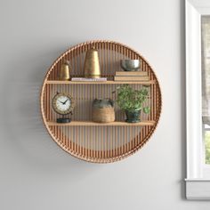 a clock mounted to the side of a wall next to a shelf filled with plants