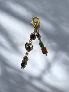 a close up of a key chain on a white cloth with beads and charms hanging from it