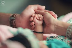 a baby's foot being held by its parent