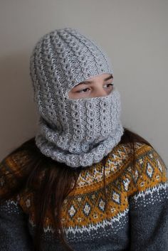 a woman wearing a knitted hat and scarf with a hood on top of her head