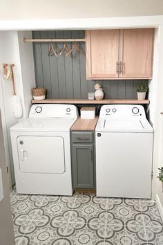 a washer and dryer in a small room with tile flooring on the walls