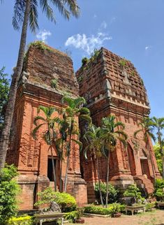 an old brick building surrounded by palm trees