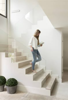 a woman is walking up the stairs with her book and looking at something in her hand