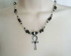 "Ankh Of Life Necklace This beautiful necklace has black obsidian nugget beads, clear glass beads, pewter silver accent beads, sterling silver plated beads, sterling silver plated chain, seed beads, pewter silver ankh of life pendant with black agate setting. 16\" long adjustable to 20\" long. Sterling silver plated lobster clasp." Symbolic Black Jewelry For Healing, Spiritual Obsidian Beaded Jewelry, Silver Obsidian Necklaces, Obsidian Beaded Jewelry For Healing, Silver Obsidian Necklace With Natural Stones, Bohemian Hematite Jewelry For Gift, Gothic Ankh Jewelry For Gift, Spiritual Metal Necklaces, Spiritual Handmade Hematite Jewelry