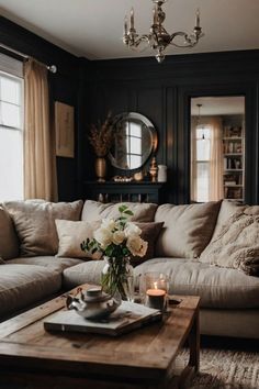 a living room with a couch, coffee table and chandelier hanging from the ceiling