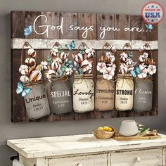 three mason jars with flowers are hanging on a wall next to a white dresser and table