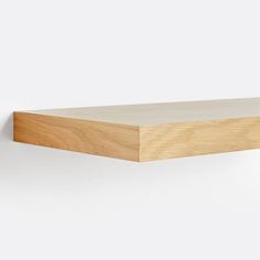 a wooden shelf on a white wall with no one in it or someone out front