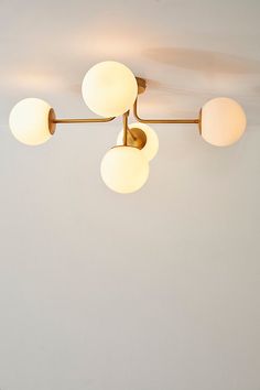 three lights are hanging from the ceiling in a room with white walls and flooring