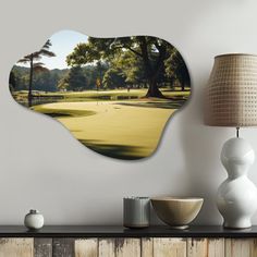 a golf course with trees and grass in the background on a wall above a table