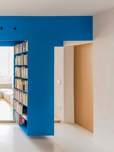 a room with blue walls and bookshelves in it