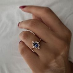 This is a stunning Oval Blue Sapphire Ring designed to be a perfect Diamond Bridal Ring. The ring is made of 14K Gold, giving it a delicate and elegant appearance that would make it a great Proposal Ring or Engagement Ring for women. Its Dainty Statement design adds a unique touch, making it a perfect gift for a Girlfriend. #WomenRing #WeddingRing #StatementRing #EngagementRing #DiamondRing #GemstoneRing #TinyRing #DaintyRing #SolitaireRing #MinimalistRing #PromiseRing #GirlfriendGift Elegant Blue Flower Ring As Gift, Blue 14k Gold Diamond Ring With Halo Design, Sapphire Cluster Ring Fine Jewelry For Gift, Sapphire Diamond Ring With Halo Design For Promise, Sapphire Proposal Ring In Fine Jewelry Style, Blue Diamond Ring With Halo Design For Promise, 14k Gold Sapphire Cluster Ring Gift, Blue Cluster Ring With Halo Design For Promise, Blue Halo Diamond Ring As Gift