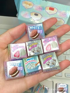 a person is holding four miniature marshmallows in front of a computer keyboard