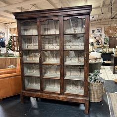 an old wooden bookcase with glass doors in a store