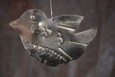 a metal bird ornament hanging from a string