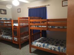 three bunk beds in a room with blue curtains