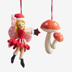 an ornament shaped like a fairy holding a mushroom and wearing a red dress