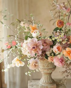 a vase filled with lots of flowers on top of a table