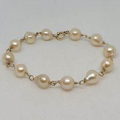 Lovely 12kt yellow twisted gold link bracelet with twelve 8.5mm cream-white freshwater pearls. The freshwater pearls have a lustrous clean nacre. The bracelet is 7.75 inches long, secured with a spring ring clasp, and weighs 10.6 grams.  Rock N Gold Creations is located in San Diego, California, serving customers locally, nationally, and internationally for over 30 years. Pre-owned jewelry and watches are evaluated before they are listed. The founder is a GIA graduate; the company adheres to GIA standards. Rock N Gold Creations has won many jewelry design competitions and has a passion for providing quality custom jewelry, fine estate jewelry, and fine watches. Classic Gold Pearl Bracelet Hypoallergenic, Classic Gold Bracelet With Pearl Drop, Classic Gold Pearl Drop Bracelet, Classic Gold Bracelet With Pearl Charm, Gold Round Pearl Drop Bracelet, Gold Pearl Bracelet With Pearl Charm For Formal Occasions, Gold Pearl Drop Bracelet, Formal Gold Bracelet With Pearl Charm, Yellow Gold Bracelet With Pearl Drop For Anniversary