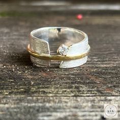 "Gorgeous mixed metal CZ band ring with satin finish. Sterling silver split band measuring approximately 11/32\" (8.6mm) and a hammered 14 karat gold plated irregular band in the center measuring approximately 1/16\" (1.5mm). This ring has a 1/8\" (3mm) CZ. .925 Sterling Silver Our ring will come in a linen bag." Silver Ring Hammered, Hammered Metal Jewelry, Wide Band Diamond Rings, Silver And Gold Ring, Mixed Metal Ring, Handmade Silver Rings, Silversmithing Jewelry, Wide Silver Ring, Unique Silver Rings