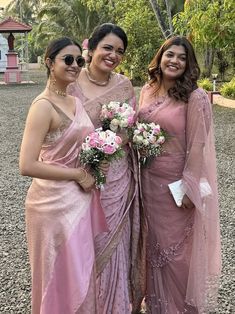 three women standing next to each other wearing pink dresses and holding bouquets in their hands