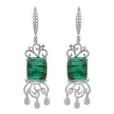 A massive pair of 25.45 carat of vivid green emerald are set along with 1.78 carat of white brilliant round diamond. The gorgeous dangle earring is a must wear for all red carpet events. The details of the earring are mentioned below: Color: F Clarity: VS Luxury Green Diamond Earrings, Luxury Green Emerald Diamond Earrings, Luxury Emerald Diamond Earrings, Formal Green Diamond Gemstone Earrings, Formal Green Gemstone Diamond Earrings, Luxury Emerald Earrings In Emerald Cut, Luxury Green Diamond Earrings Gift, Luxury Green Diamond Earrings For Gift, Luxury Green Emerald-cut Earrings