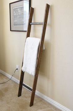 a ladder leaning against the wall with a white towel hanging on it's side