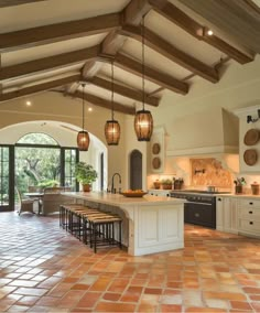 a large kitchen with an island in the middle and lots of lights hanging from the ceiling