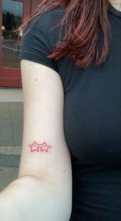 a woman's arm with two stars on the left side of her right arm