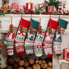 christmas stockings hanging from a fireplace with presents on the mantel and tree trunks in front