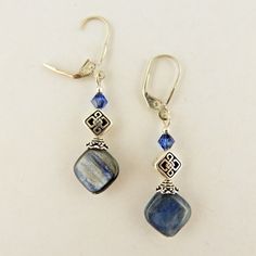 Silver plated Celtic Knot Post earrings handcrafted using: Silver plated Celtic Knot Post beads 12mm Diamond shaped Genuine Kyanite gemstone beads 4mm Dark Sapphire genuine Swarovski Crystal bicone beads Silver plated Bead caps Sterling silver lever back ear wires This gemstone is thought to align with all chakras, like wi-fi that's perpetually on. Its abilities are also believed to include stimulating communication, growing awareness of others, perseverance against challenges, promoting balance Elegant Adjustable Beaded Earrings With Gemstone Beads, Gemstone Beaded Dangle Earrings For Jewelry Making, Gemstone Beads Dangle Earrings For Jewelry Making, Sterling Silver Jewelry With Round Beads And Ear Wire, Dangle Beaded Earrings With Gemstone Beads For Jewelry Making, Sterling Silver Beaded Jewelry, Silver Jewelry With Gemstone Beads, Handmade Silver Crystal Earrings, Sapphire Beaded Jewelry Gift