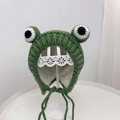 green with wool Frog Earflap Beanie Cap Playful Adjustable Acrylic Hats, Warm Playful Cap Beanie, Playful Knit Hat One Size Fits Most, Playful Knit Hat One Size, Playful Warm Acrylic Hats, Playful Knit Beanie, Playful Knitted Bonnet, One Size, Cute Winter Hats With Ears, Adjustable Knitted Mini Hats For Winter