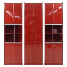 three red metal storage cabinets against a white background with no one in the photo looking at them