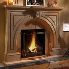 a fire place in a living room with candles on the mantle and pictures above it