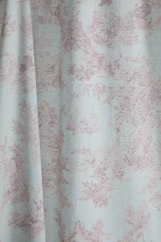 a close up view of a curtain with pink and white flowers on the fabric,