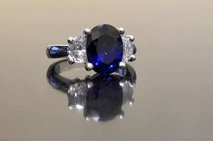 Dekara Designs Collection Metal- 90% Platinum, 10% Iridium. Stones- 1 Natural Untreated 3.88 Carat Oval Cut Ceylon Blue Sapphire. 2 Moon Cut Diamonds, F-G Color VS1 Clarity 0.77 total carats This ring is a size 6, but could be sized up or down a few sizes. This ring could be made in your specific size within 5-10 business days. Could take a little more time due to the ceylon sapphire being a rare stone. The sapphire may be a bit smaller or bigger. We can make the same design in a smaller or bigg Formal Blue Sapphire Ring Gia Certified, Blue Oval Sapphire Ring With Vvs Clarity, Oval Blue Sapphire Ring With Vvs Clarity, Classic Blue Sapphire Diamond Ring, Blue Gia Certified Diamond Ring For Formal Occasions, Classic Blue Sapphire Ring For Formal Occasions, Elegant Blue Sapphire Ring With Vvs Clarity, Blue Sapphire Three Stone Ring With Diamonds, Blue Three Stone Round Cut Diamond Ring