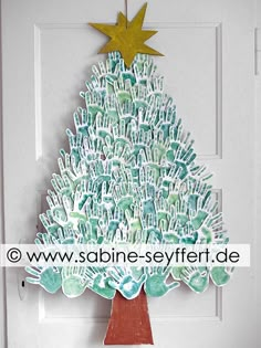 a christmas tree made out of handprinted paper