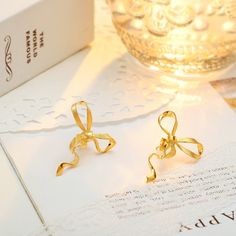 Who says everyday can't be charming? Gold Bow Earrings bring the coquette aesthetic with their classic ribbon design, meticulously designed with gleaming gold. Lightweight and comfortable, these high-quality earrings boast a smooth, shiny finish and long-lasting color. Effortlessly versatile, they pair perfectly with any outfit. Get ready to transform your everyday look from ordinary to oh-so-cute! DETAILS Plating: 18k Gold  Materials: 18k Gold on 925  Sterling Silver Size: 1.18"*0.98"(3.0cm*2.5 Chic Gold Earrings With Decorative Bow, Elegant Butterfly Knot Earrings For Gift, Elegant Butterfly Knot Earrings As Gift, Gold Earrings With Elegant Design For Gift, Chic Gold Jewelry With Butterfly Knot, Gold Earrings With Decorative Bow As Gift, Gold Earrings With Decorative Bow For Formal Occasions, Gold Dainty Bow Earrings, Gold Dainty Earrings With Bow