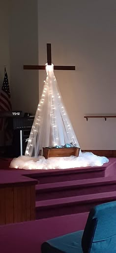 a church alter with a cross on top and lights in the middle, all lit up