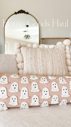 a pillow with ghost faces on it sitting on a couch