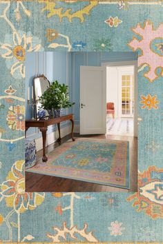 a blue room with an ornate rug, mirror and plant in the corner on the floor