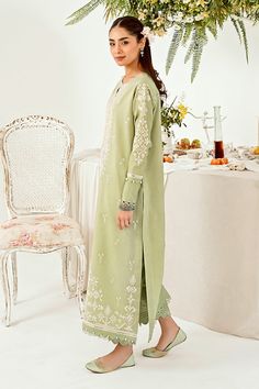 Introducing "Mint Majesty," a captivating ensemble in our summer collection. This pastel green outfit exudes a sense of freshness, adorned with intricate chikankari embroidery delicately tracing the neckline, hemline (daman), and sleeves. Paired with tailored trouser pants, it stands as a class apart, epitomizing effortless sophistication and timeless charm. Step into the realm of elegance with "Mint Majesty," where every detail speaks of refined grace and unmatched allure.