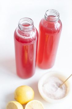 two jars filled with liquid next to lemons on a white surface and the words, natural electrolyte drink