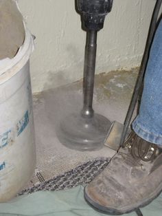 a pair of dirty shoes next to a parking meter and pail on the floor