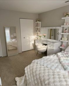 a bedroom with a bed, desk and mirror