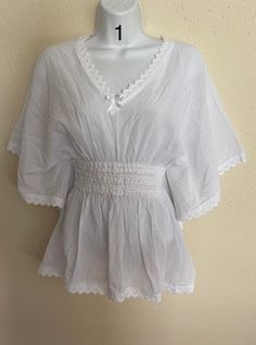 This beautiful artisanal blouse is made in Oaxaca, Mexico. The blouse has a loose-fitting and it has embroidery around it. Feel free to contact if you have any questions! White Folk Style V-neck Blouse, Embroidered V-neck Top For Daywear, Flowy Cotton V-neck Blouse, V-neck Embroidered Blouse For Vacation, Casual Embroidered Top For Summer Daywear, Embroidered V-neck Peasant Top For Beach, Long Sleeve Smock Top For Vacation, Elegant Lace Trim Blouse For Vacation, Bohemian Tops With Lace Trim For Vacation